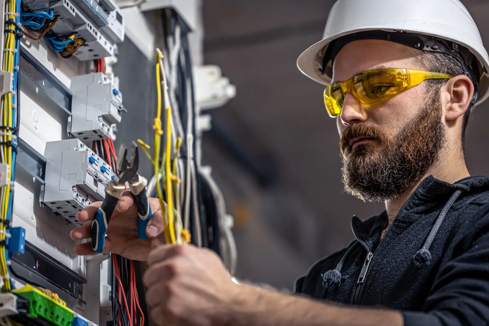 Electrician working on a circuit breaker panel.