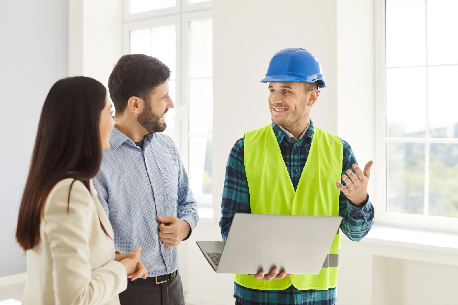 Foreman Discussing Home Renovation Project With Couple Using Laptop