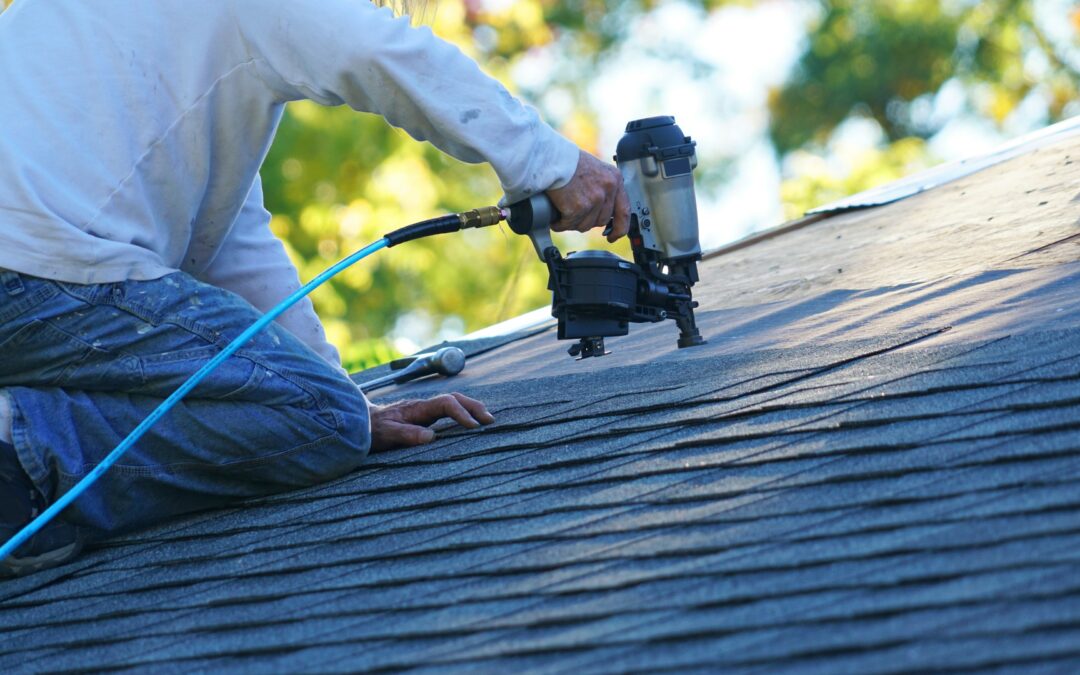 Contractor works on roof with nail gun.