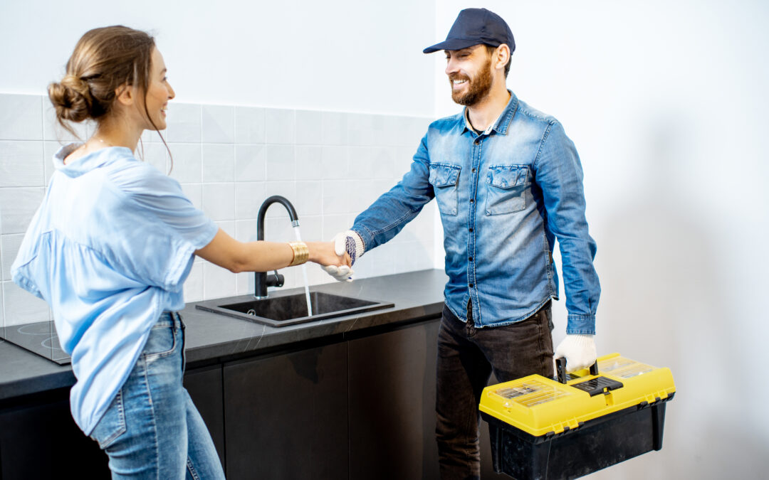 Contractor shaking hands with a client after completing a job in her kitchen.