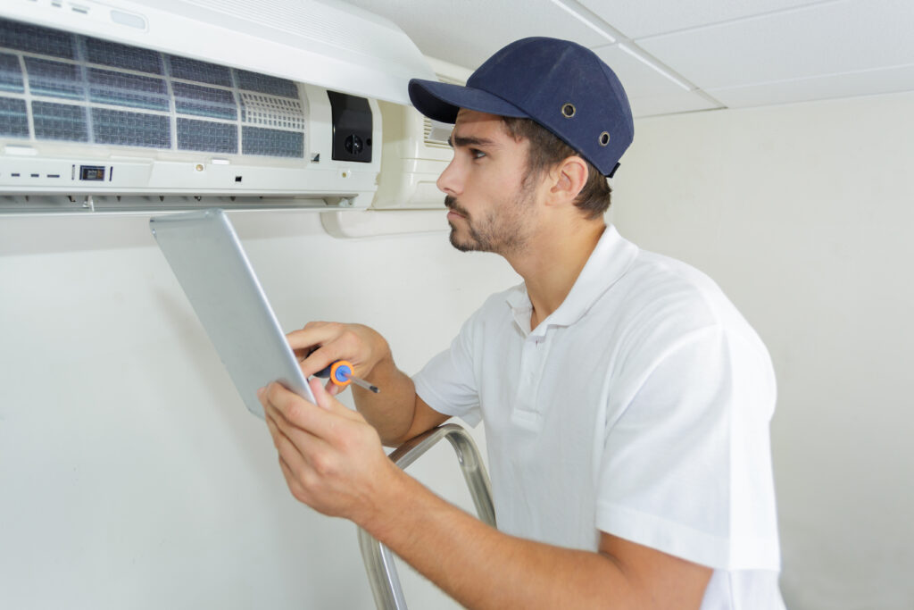 young HVAC contractor working carefully and seriously at clients office